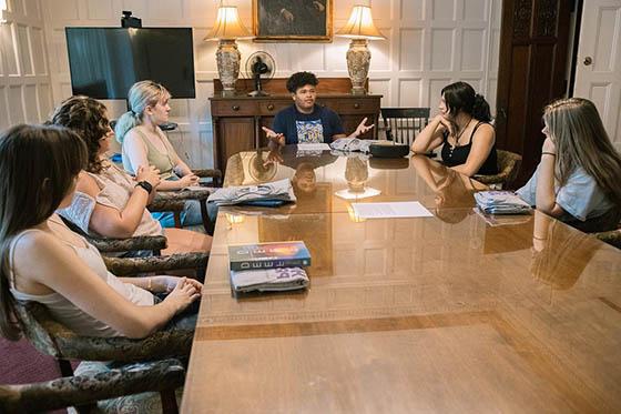 Photo of a male Chatham University student seated next to classmates, paying attention to an unseen lecturer